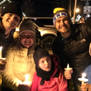 Group of individuals holding candles.
